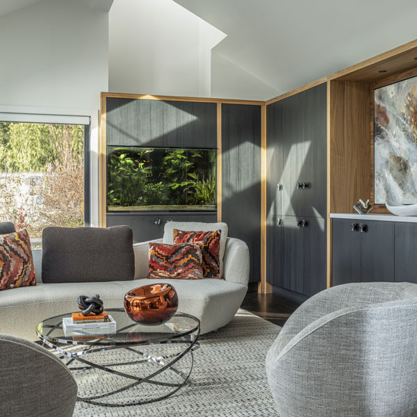 Modern living room with curved sofa, fish tank, and art piece in Westchester County, NY